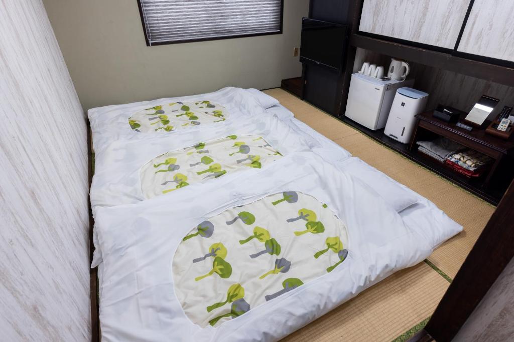 a bed with white sheets and green frogs on it at Select Inn Fujisan Gotemba in Gotemba