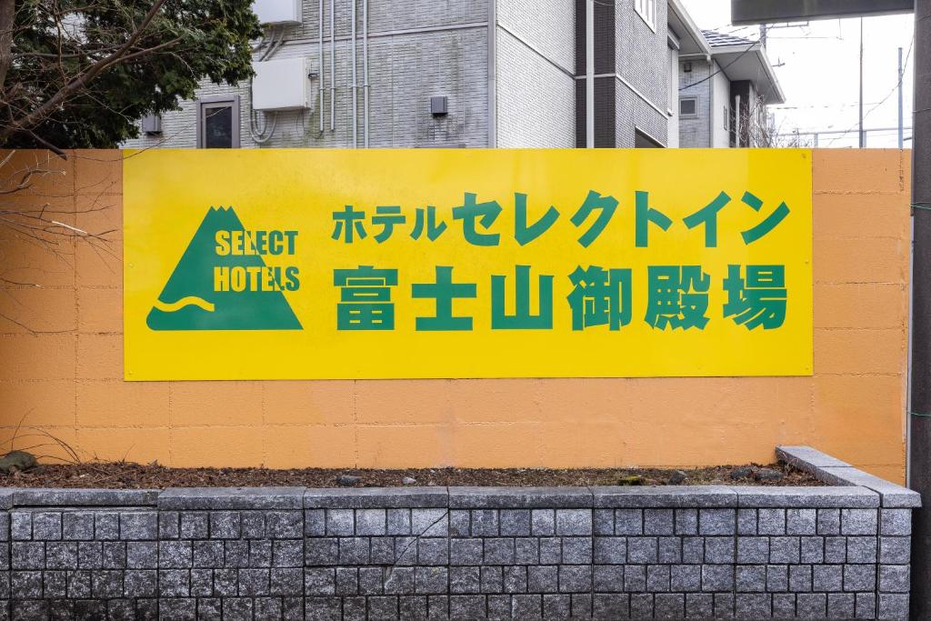 a yellow sign on the side of a building at Select Inn Fujisan Gotemba in Gotemba