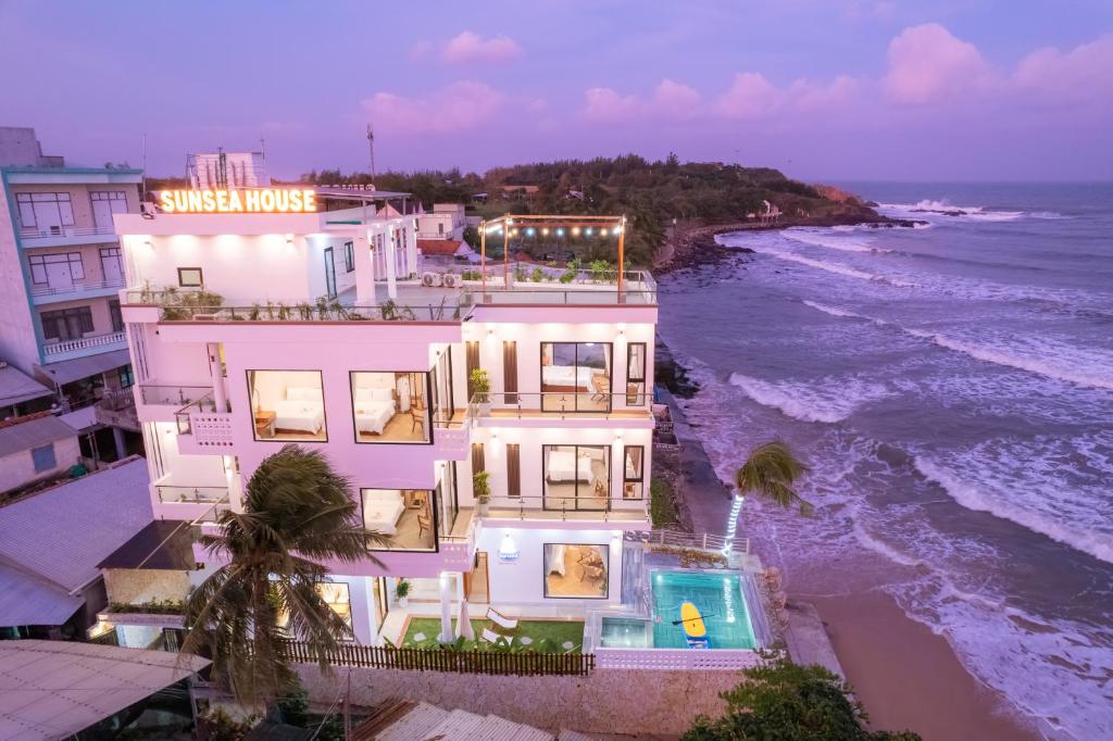 a building on the beach next to the ocean at Sunsea House-Đá Đĩa Phú Yên in Tuy An