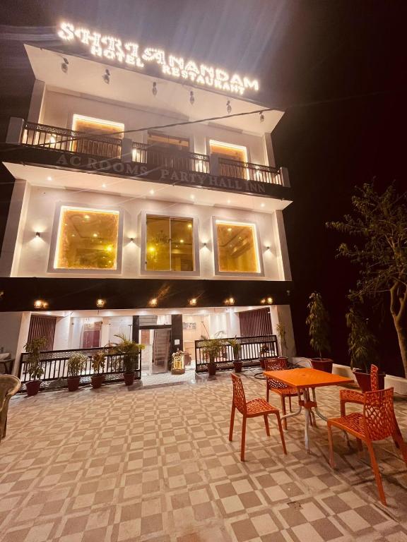 a building with a table and chairs in front of it at SHRI ANANDAM Inn in Isauli