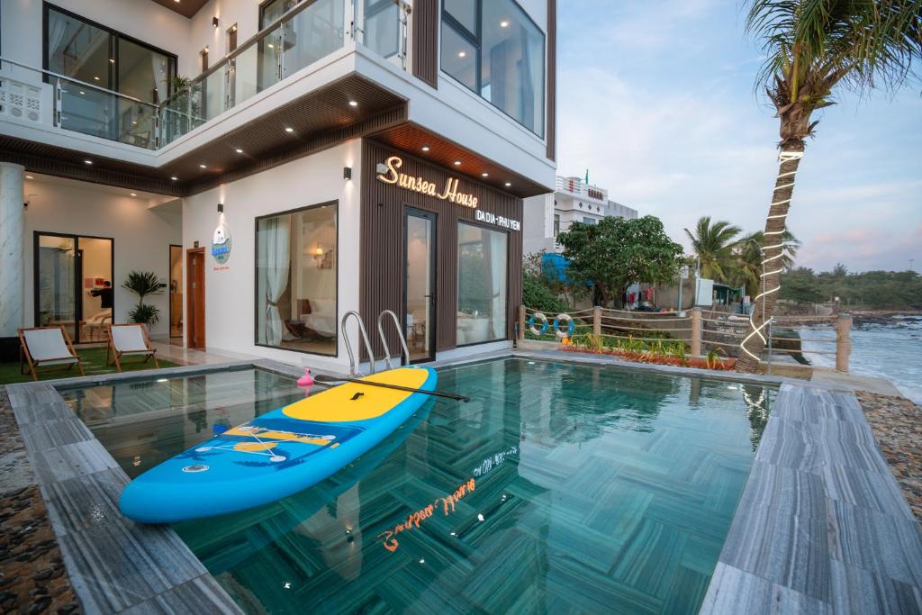 a house with a swimming pool with a surfboard in it at Sunsea House-Đá Đĩa Phú Yên in Tuy An