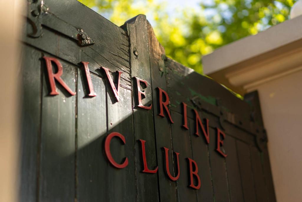 a black sign with red writing on the side of a building at The Riverine Club in Wagga Wagga