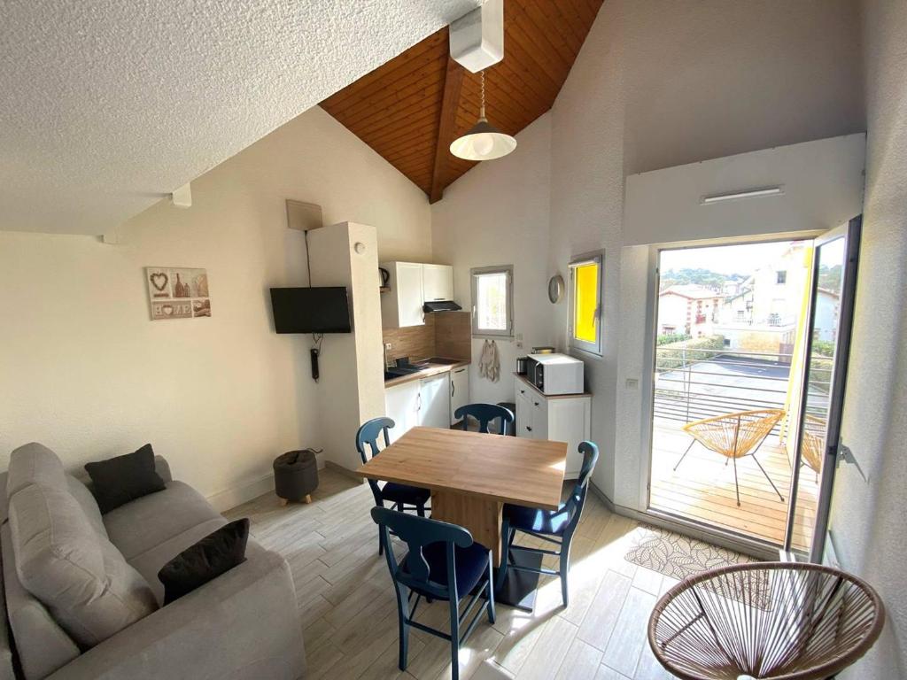 Il comprend un salon et une cuisine avec une table et un canapé. dans l'établissement Duplex rénové face à la plage avec balcon et parking - FR-1-738-41, à Saint-Palais-sur-Mer