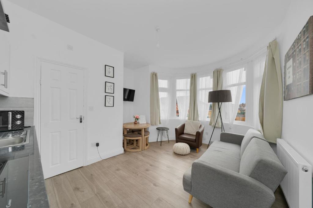a living room with a couch and a table at Startlet Stays Apartments - On Elizabeth Line with Free Parking in London