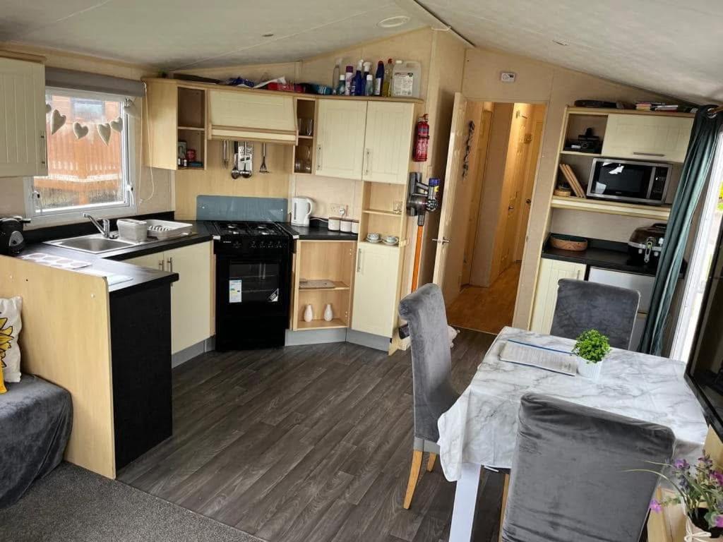 埃克斯茅斯Haven Devon Cliffs Caravan的一间厨房和带大篷车桌子的用餐室
