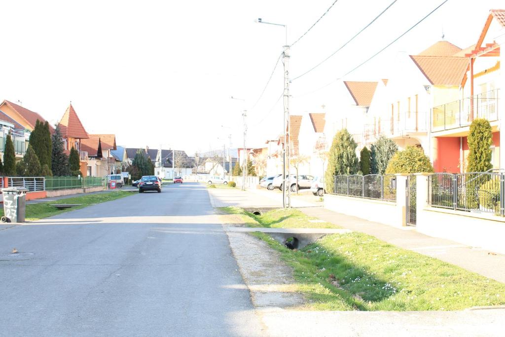 an empty street in a residential neighborhood with houses at Harkány-Szt. István Apartman in Harkány