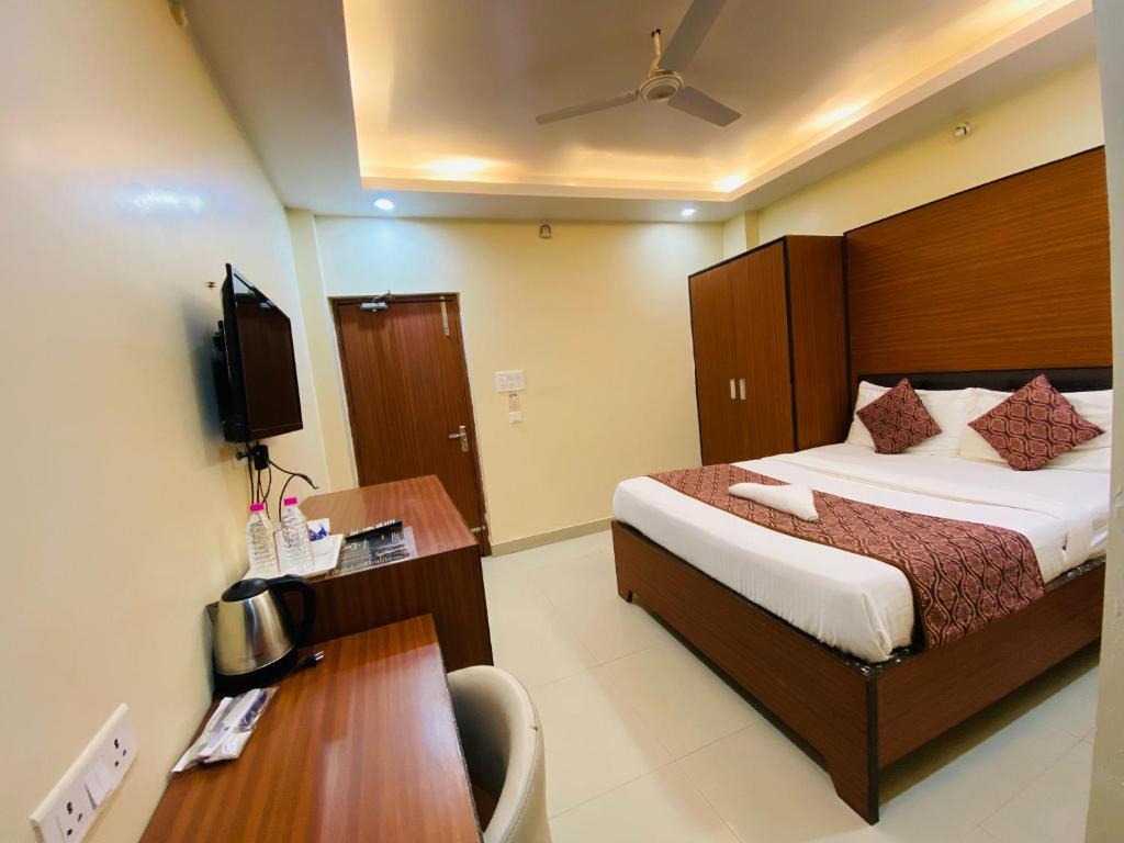a bedroom with a bed and a desk and a television at Kamat Inn in Bankipur