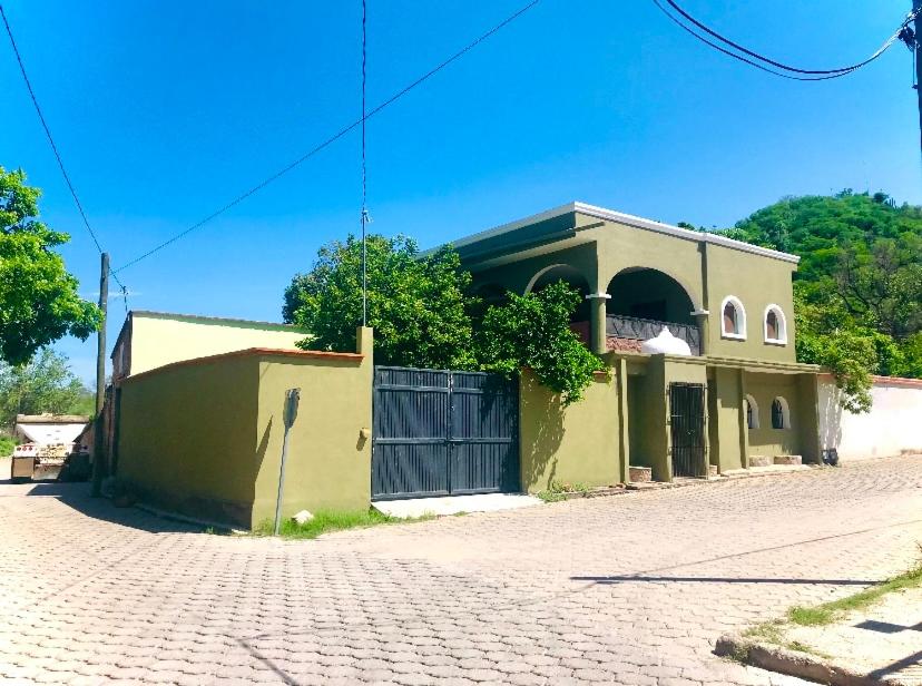 ein gelbes Gebäude mit einem Tor auf einer Backsteinstraße in der Unterkunft Casa Corazon de Alamos in Álamos