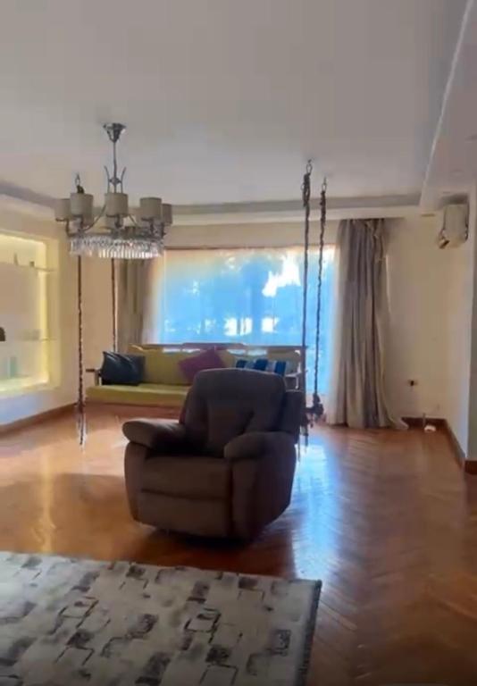 una sala de estar con una silla y un sofá en شقه بكورنيش النيل, en El Cairo