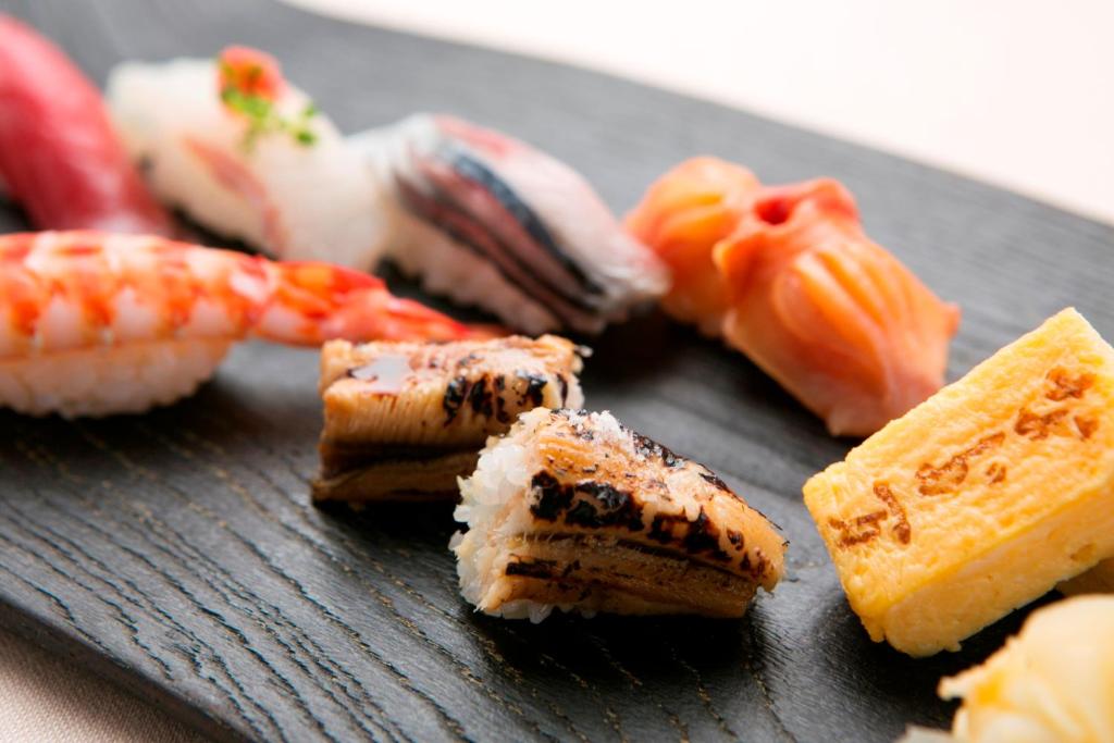 a black plate with sushi and seafood on it at Hyatt Regency Tokyo in Tokyo