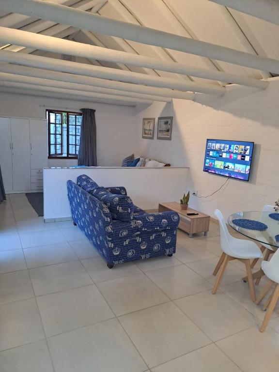 a living room with a couch and a table at Beach Walk Cottage in Plettenberg Bay