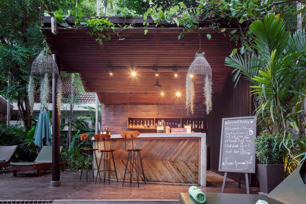 an outdoor bar with stools and a chalk board at Lynnaya Urban River Resort in Siem Reap