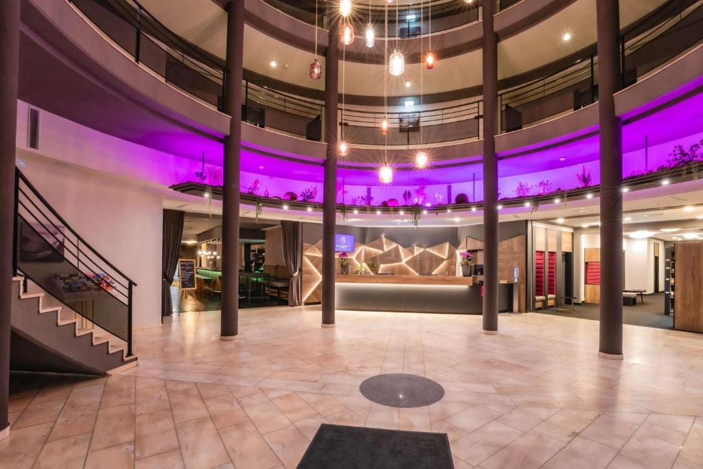 a large room with a stage with purple lights at PLAZA INN Salzburg Messe in Salzburg