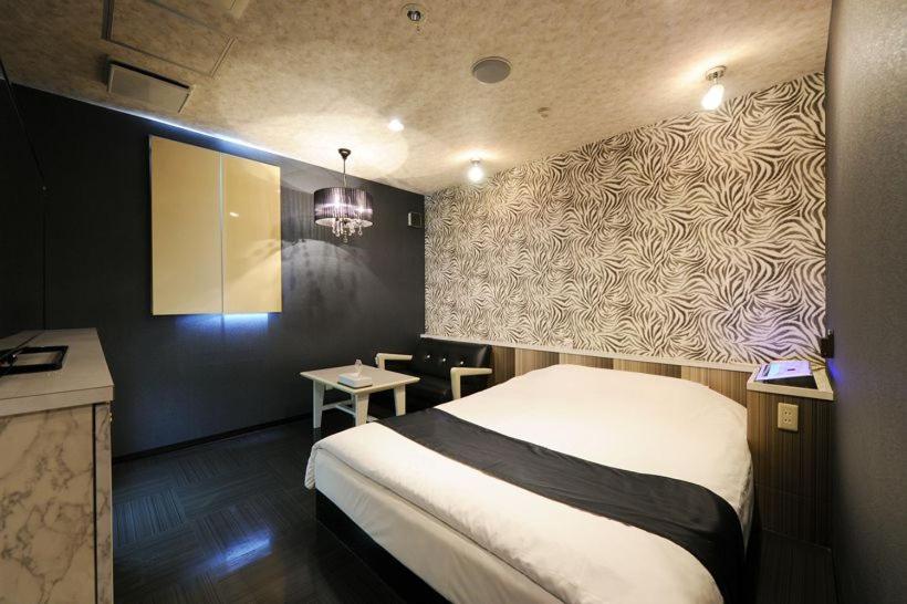 Postel nebo postele na pokoji v ubytování ホテルぴみ袋井店 大人専用