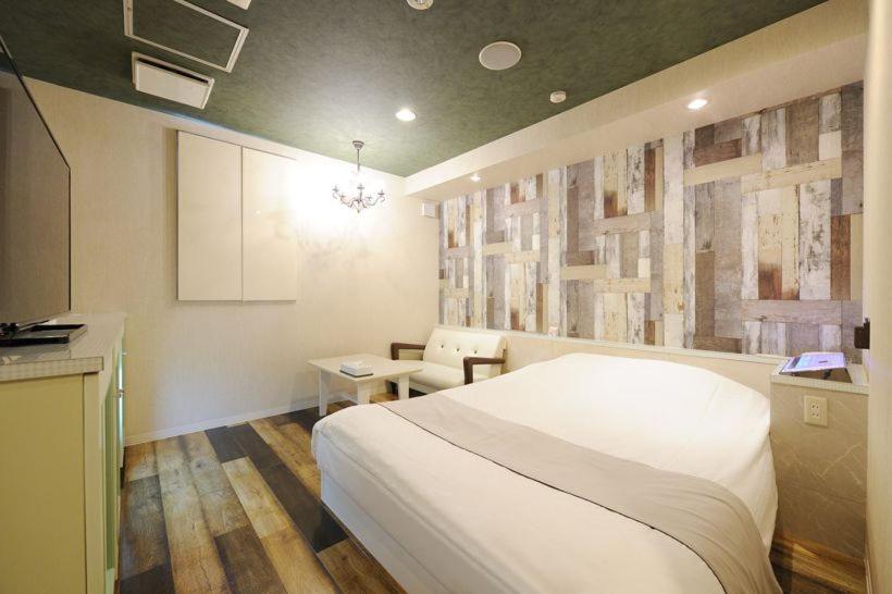 Postel nebo postele na pokoji v ubytování ホテルぴみ袋井店 大人専用