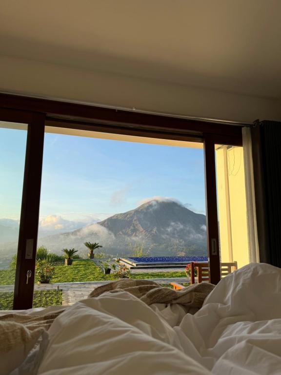 Ce lit se trouve dans une chambre avec vue sur la montagne. dans l'établissement Pinggan Vista Alam, à Baturaja