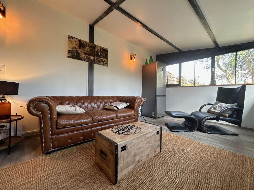 un salon avec un canapé en cuir et une table dans l'établissement Mais 5 pièces CHATELAILLON PLAGE - CL000-085, à Châtelaillon-Plage