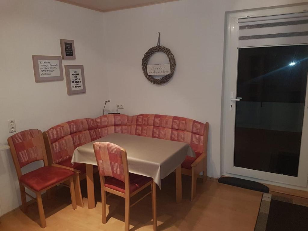 ein Esszimmer mit Tisch und Stühlen und einem Fenster in der Unterkunft Elsbach-Perle in Oberelsbach