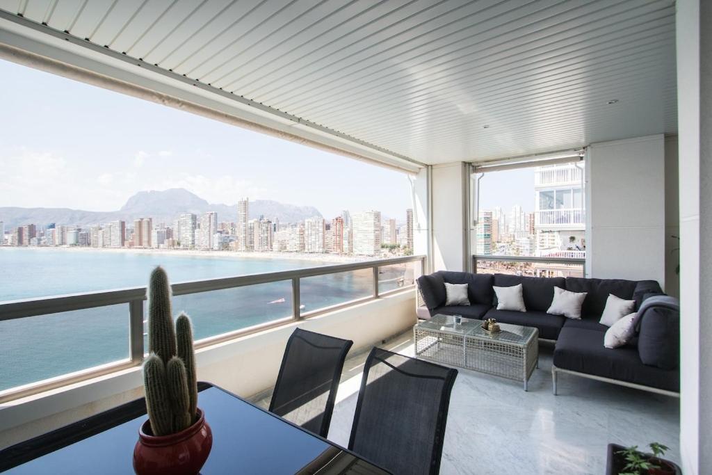 a living room with a couch and a view of the water at Excellent apartment in front of the sea! in Benidorm