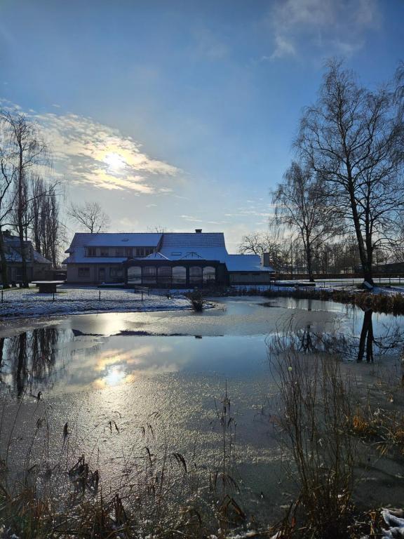 a pond in front of a building with a building at Colliemolenhoeve 
