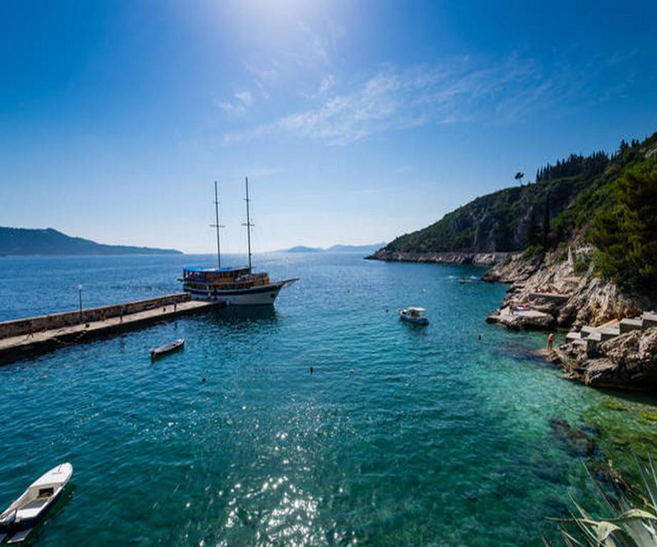 un barco está atracado en un muelle en el agua en Holiday Home Platanus, en Trsteno