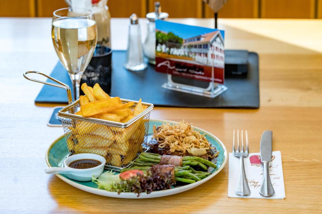 a plate of food on a table with a glass of wine at Gasthof - Auszeit im Bad Diezlings - Adults only in Hörbranz