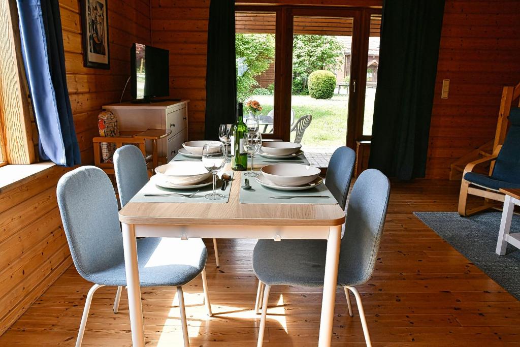 a dining room table with chairs and a table and chairsktop at Feriendorf Blauvogel Blauvogel 031 in Hasselfelde
