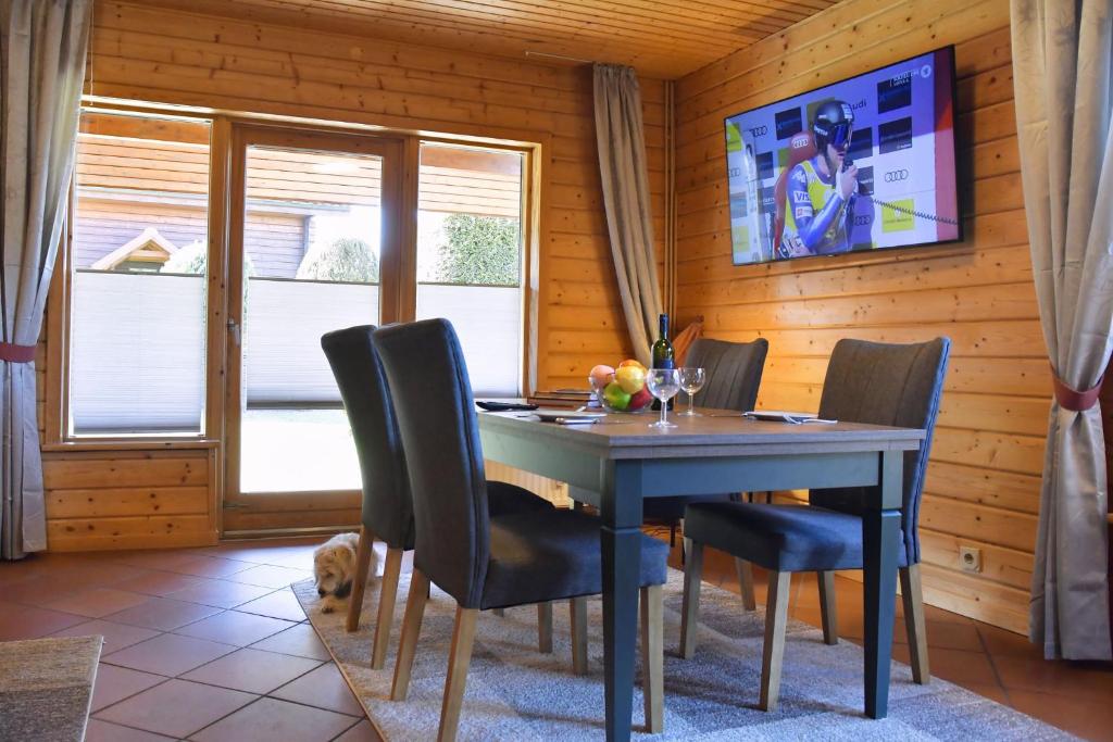 a dining room with a table and chairs and a tv at Feriendorf Blauvogel Blauvogel 054 in Hasselfelde