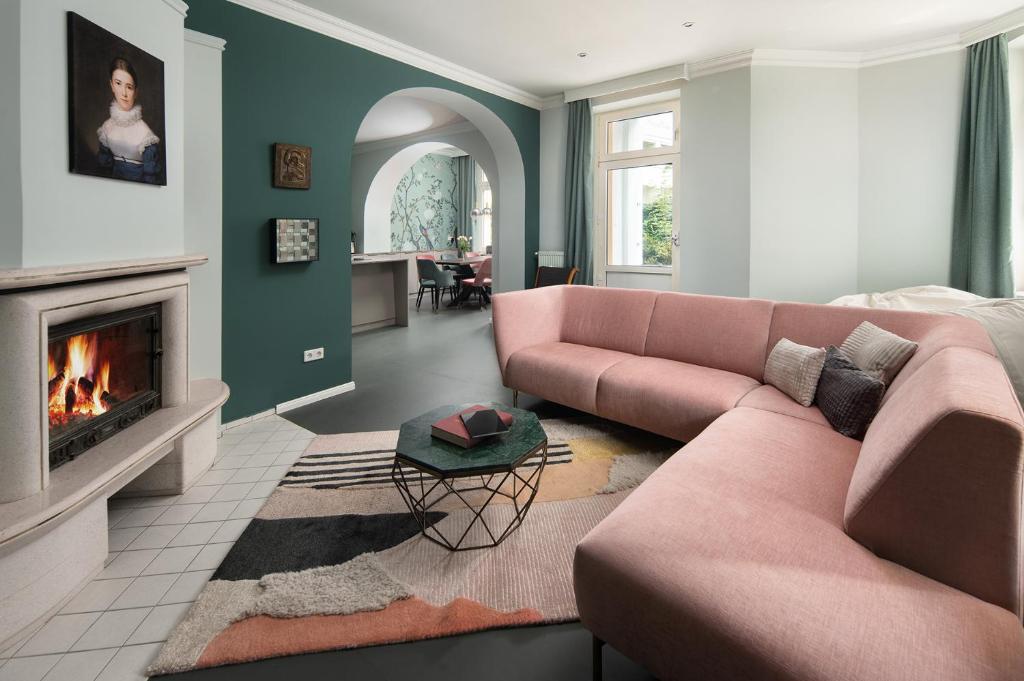 a living room with a pink couch and a fireplace at Maria Luise in Bad Harzburg