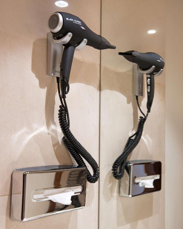 a phone hanging on a wall with two phones at NH Collection Marbella in Marbella