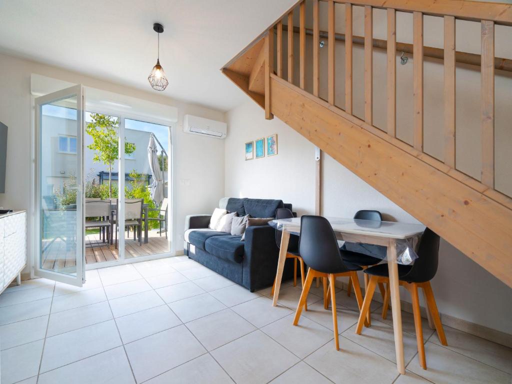 - un salon avec un escalier, une table et des chaises dans l'établissement La Dune 54 - Villa 3P6, à Valras-Plage