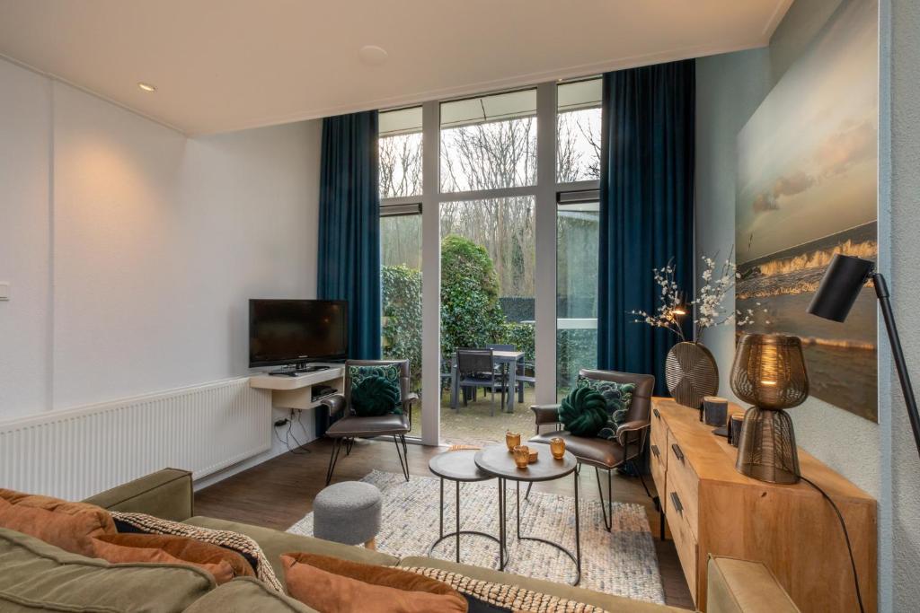 BiggekerkeにあるWelcome in - WoesteHoeve Sfeervol Vakantiehuisje in Zeeland aan Zee, Dicht bij Strand & Natuurのソファとテレビのあるリビングルーム