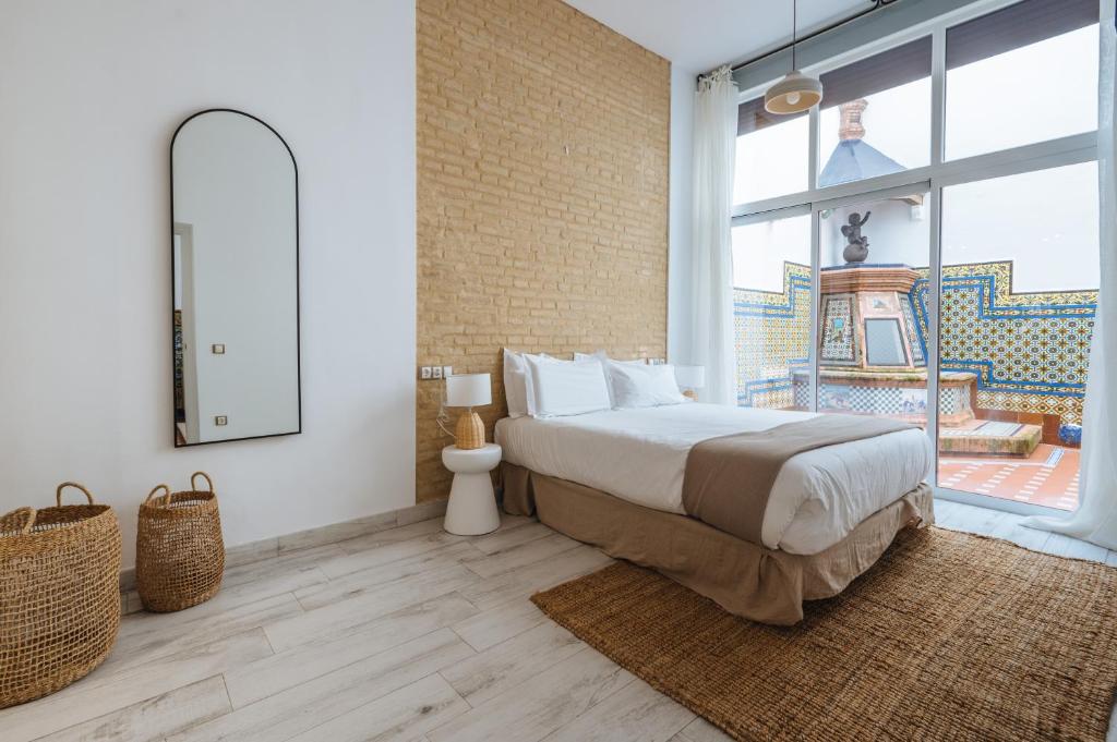 a bedroom with a bed and a large window at Apartamentos "El Escondite de Triana" in Seville