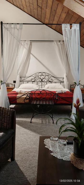 a bedroom with a bed with curtains and a table at Hotel Plzeňský Dvůr in Frýdek-Místek