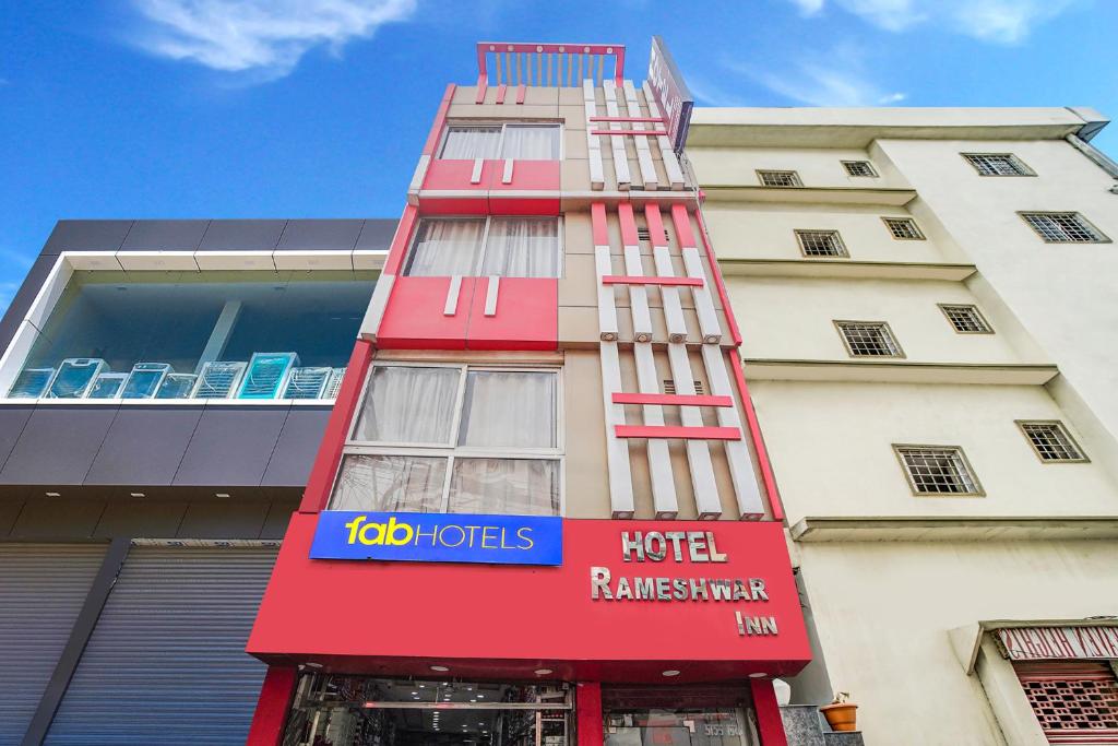 a red building with a hotel reimbursement sign on it at Via Rameshwar Inn in Jhūsi