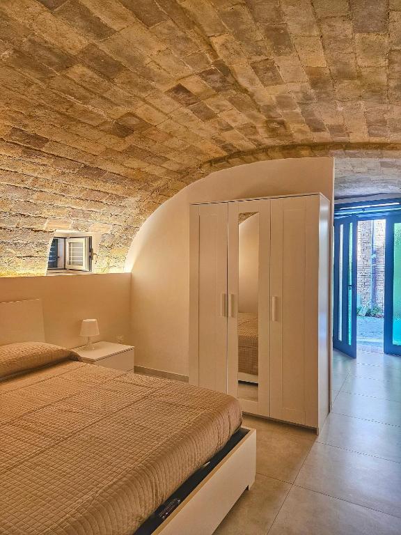 a bedroom with a bed and a brick wall at La Stanza di Chiara - Maison à Porter in Vasto