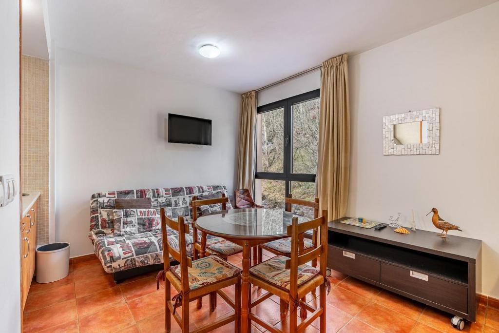 ein Wohnzimmer mit Tisch, Stühlen und Sofa in der Unterkunft Monte Gorbea Mumu 7 B in Sierra Nevada