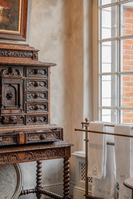 an antique piano in a room with a chair at The Notary in Bruges
