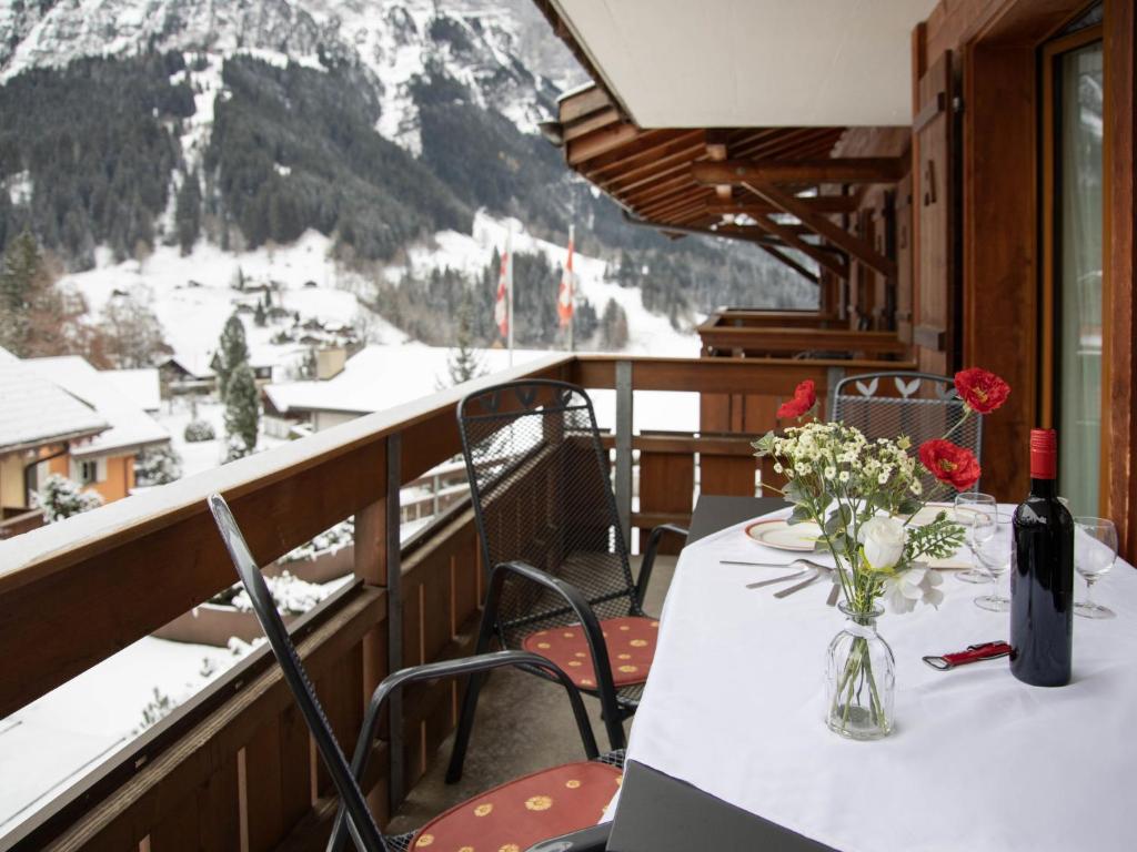 a table with a vase of flowers on a balcony at Apartment Chalet Abendrot apARTments-25 by Interhome in Grindelwald