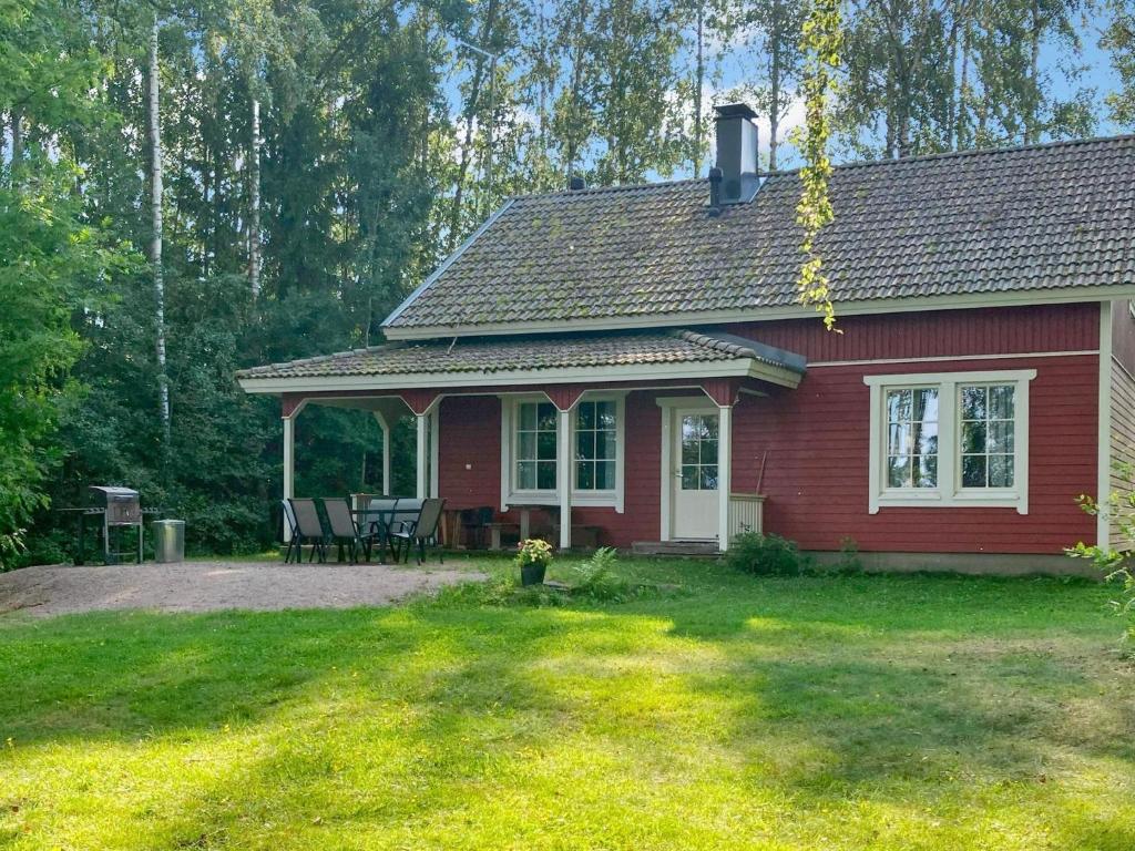 ein rotes Haus mit einem Tisch und Stühlen im Hof in der Unterkunft Holiday Home Patrakka by Interhome in Alvettula
