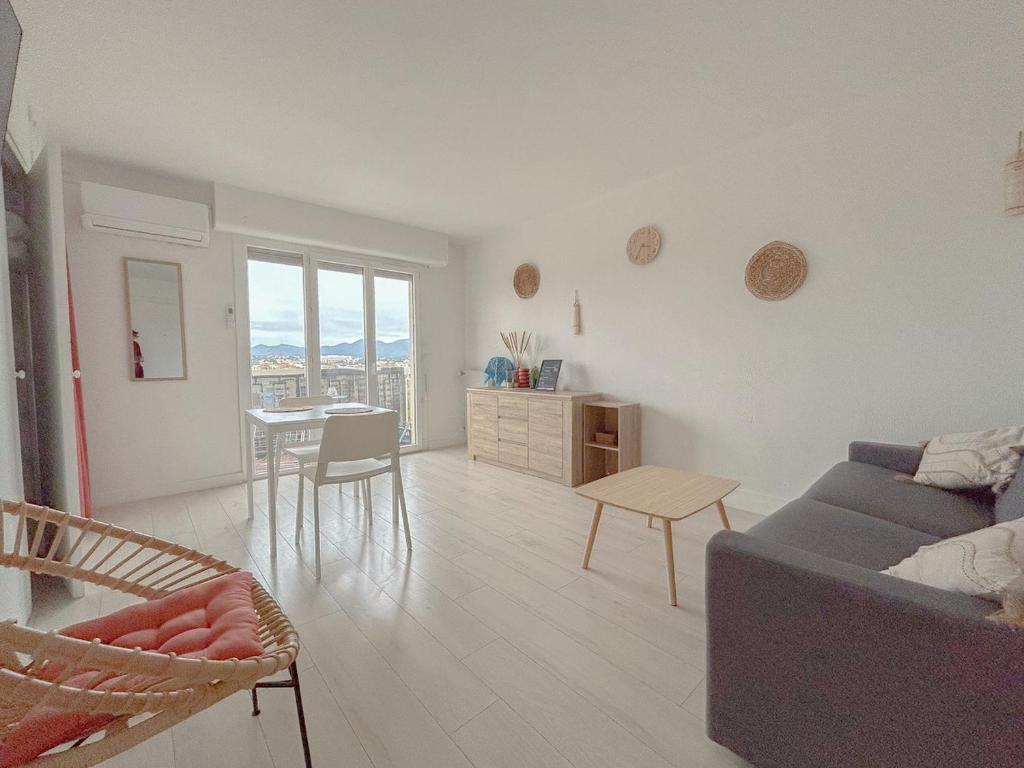 un salon avec un canapé et une table dans l'établissement Charmant studio bohème vue dégagée moderne, à Fréjus