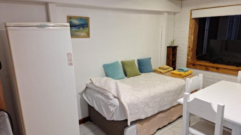 a bedroom with a bed with blue and green pillows at Departamentos El Bolson in El Bolsón