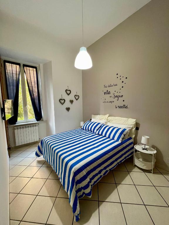 ein Schlafzimmer mit einem Bett, das mit einem blau-weiß gestreiften Laken bezogen ist. in der Unterkunft Casa MaVi in Neapel