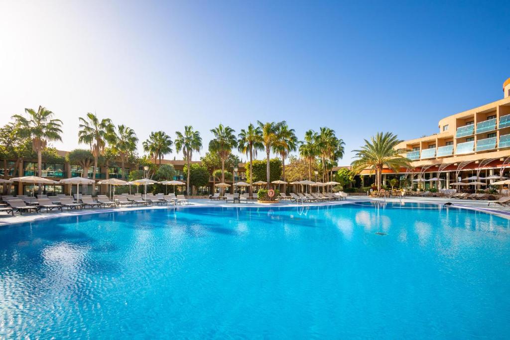 a large pool with chairs and umbrellas in a resort at MUR Faro Jandia Fuerteventura & Spa in Morro del Jable