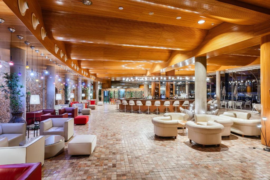 a lobby with a bar with couches and chairs at MUR Faro Jandia Fuerteventura & Spa in Morro del Jable