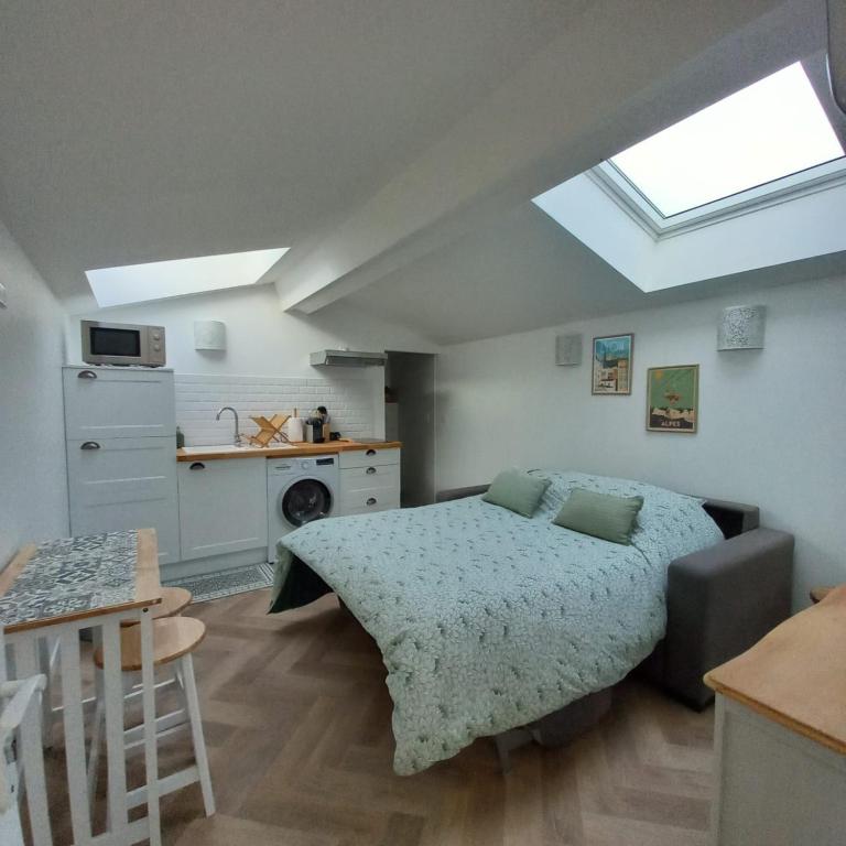 Cet appartement comprend une chambre avec un lit et une cuisine avec une fenêtre. dans l'établissement La Maunia Studio, à Montceaux