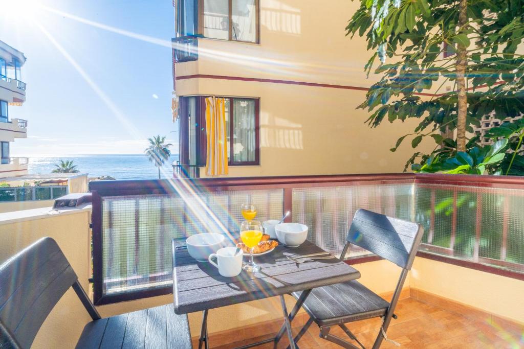 stół i krzesła na balkonie z widokiem na ocean w obiekcie Casa Linda, Front the beach La Lucera, Ribiera del Sol Wifi, AC, Private Parking, Petfriendly w mieście Sitio de Calahonda