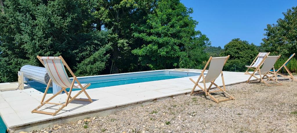 Trois chaises et une piscine en face de quelques arbres dans l'établissement La Londonniere, à Marcillac-Saint-Quentin