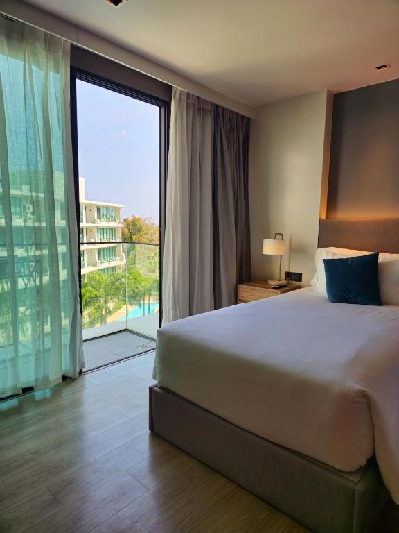 a bedroom with a large bed and a large window at Super Studio La Vita 2 pool in Rawai Beach