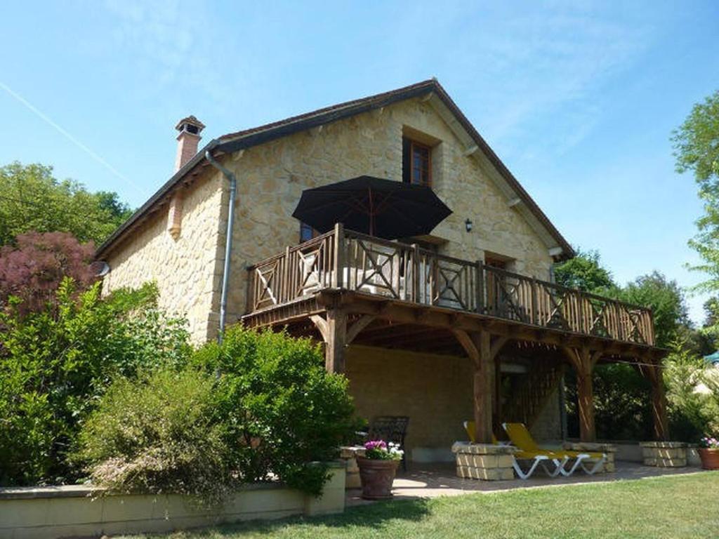 Cette maison dispose d'un balcon avec un parasol. dans l'établissement La Maison au Bord du Lac, à Groléjac